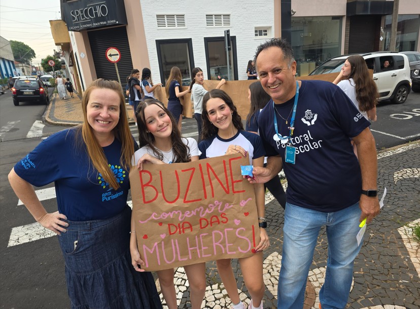 Alunos da Pastoral Escolar entregando bombons e mensagens para mulheres em homenagem ao Dia da Mulher