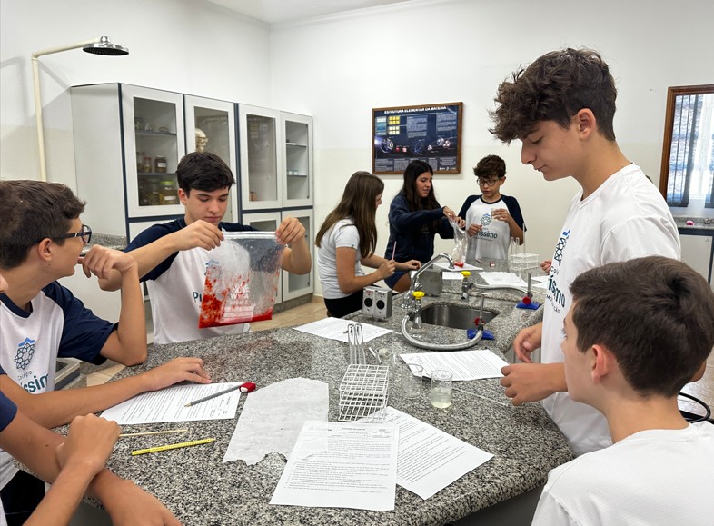 Alunos observando DNA de morango em experimento de biologia
