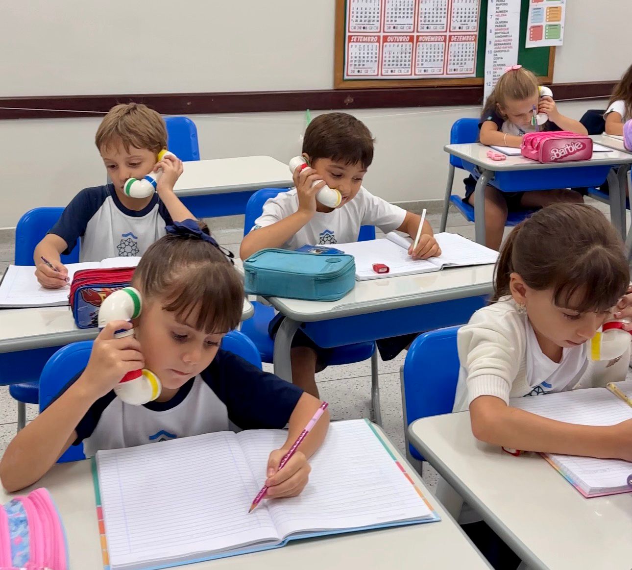 Criança utilizando sussurro fone durante atividade de leitura